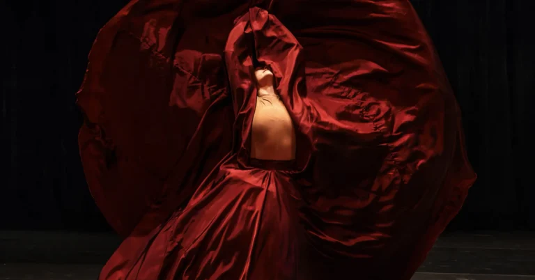Columbia Classical Ballet dancer enveloped in flowing red fabric onstage